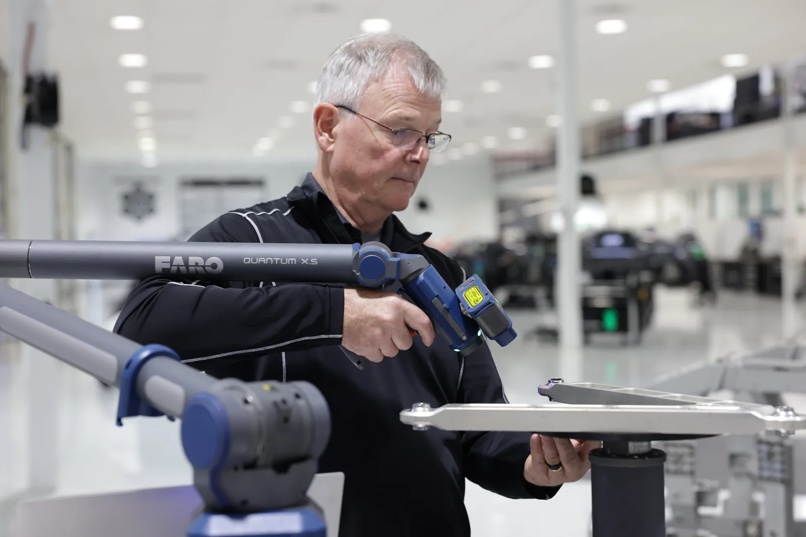 Brazo FARO Quantum X.S con cabeza láser FAROBlu escaneando un componente de aluminio mecanizado