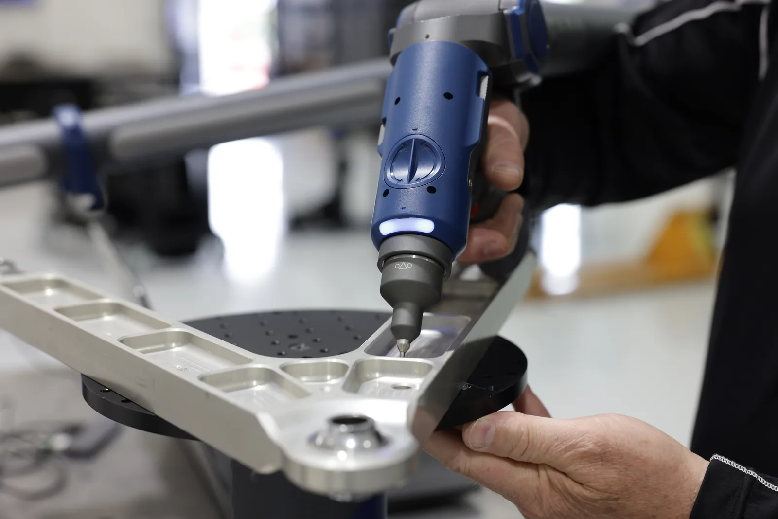 Palpador de contacto del FARO Quantum X midiendo la geometría interna de un componente de aluminio mecanizado